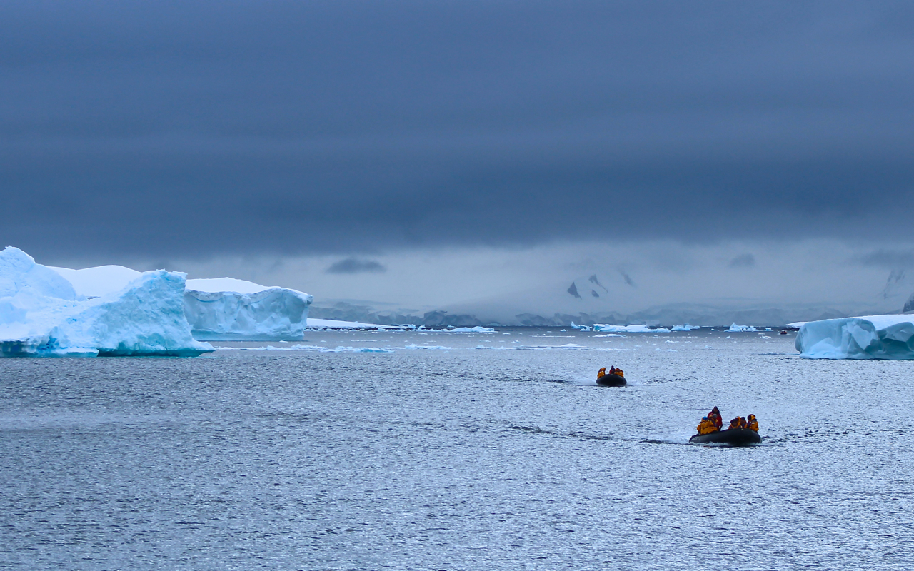 Two groups of ten passengers navigate massive icebergs by Zodiac on a recent Antarctic Explorer expedition. Photo: Miranda Miller