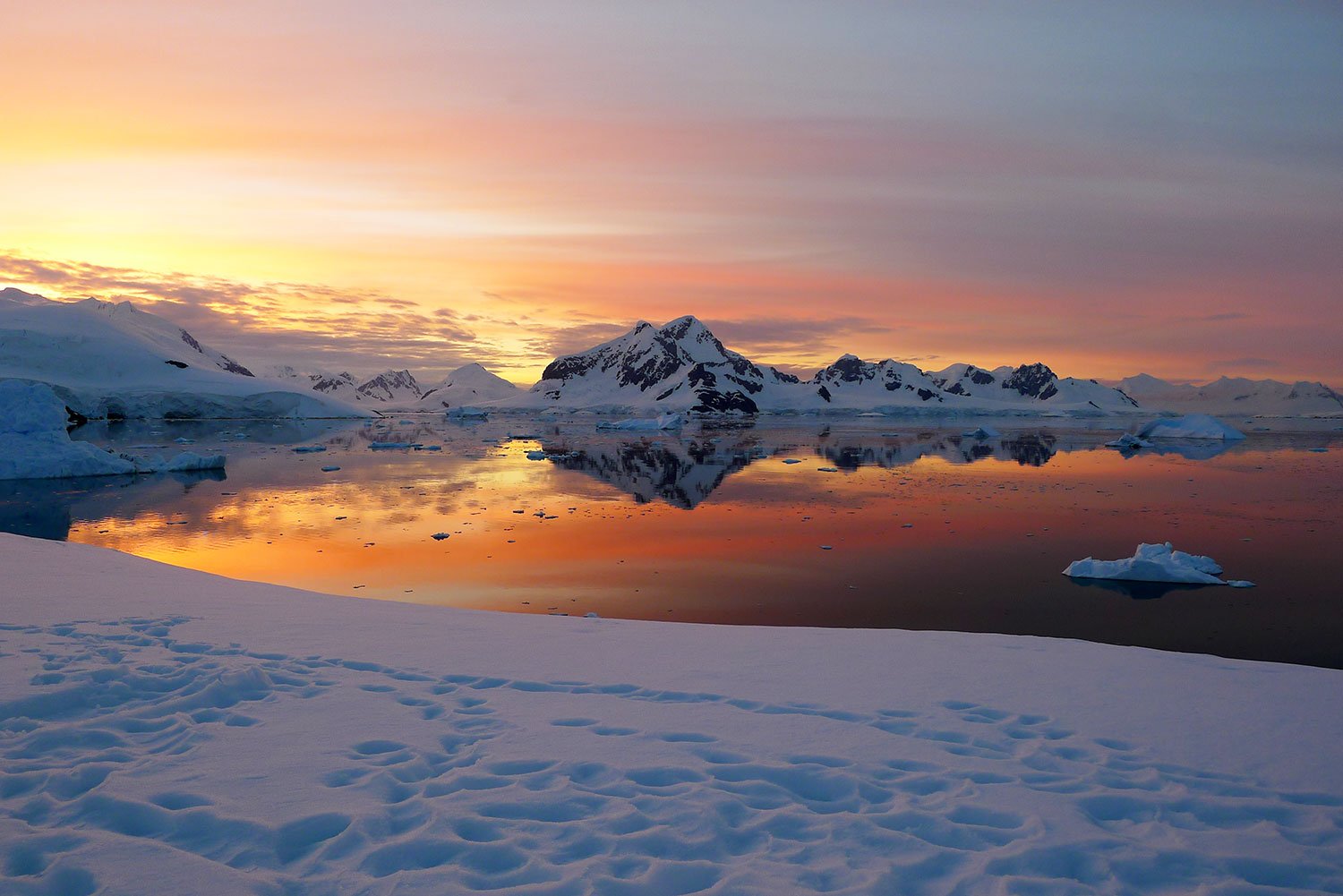 The sun sets over Leith Cove, Antarctica, setting the sky alight with spectacular hues of pink, orange and red.