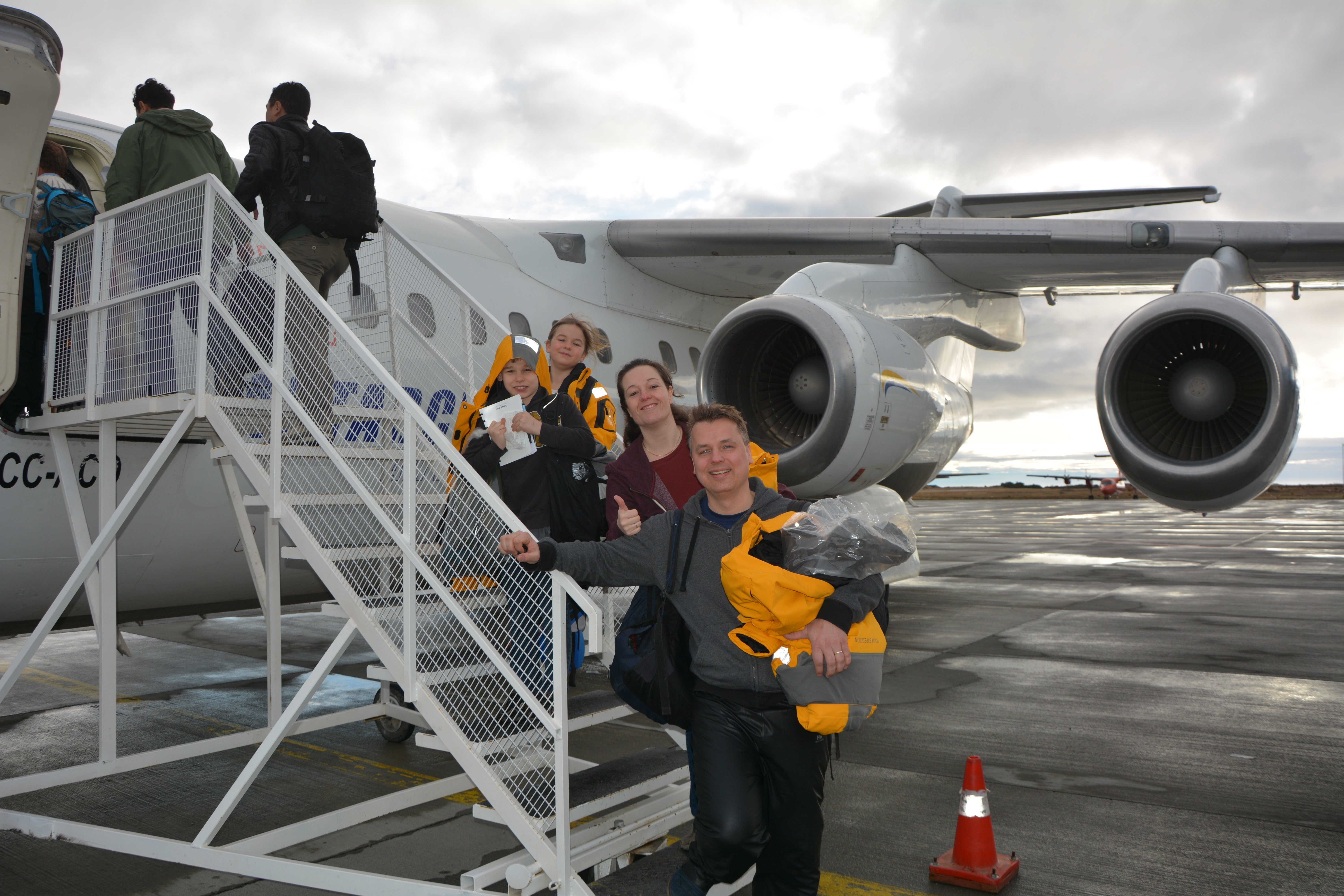 A family steps off their charter flight on a polar Fly-Cruise expedition.