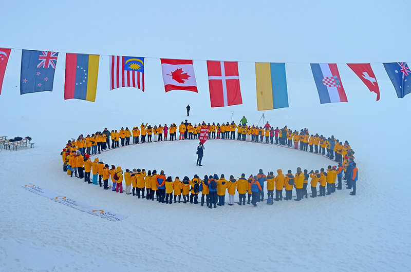 Quark passengers at the North Pole, framed by flags-Arctic